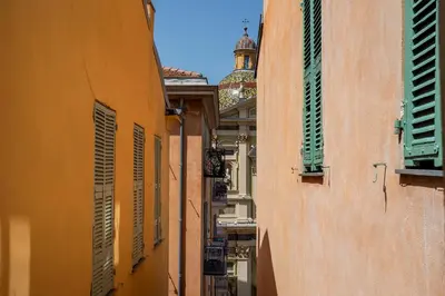 an alley between two buildings with green shutters at VUE ROSSETTI AP4465 by Riviera Holiday Homes in Nice