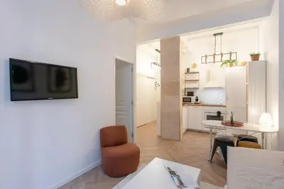 a living room with a table and a tv on a wall at #55 Sun terrace AC & Wifi 10mins walk to Sea & oldtown in Nice
