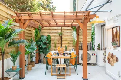 a patio with a table and chairs under a wooden pergola at #55 Sun terrace AC & Wifi 10mins walk to Sea & oldtown in Nice