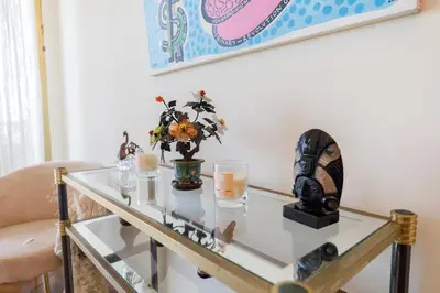 a glass table with a vase of flowers and candles at Palais D'orient in Nice