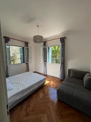a bedroom with a bed and a couch and two windows at Seaside Jungle Retreat in Nice