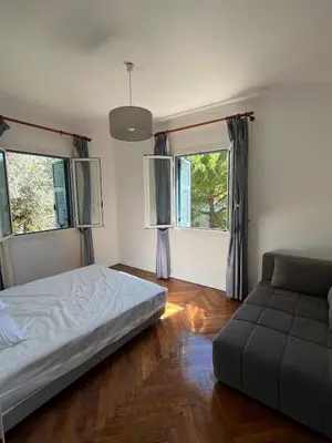 a bedroom with a bed and a couch and windows at Seaside Jungle Retreat in Nice