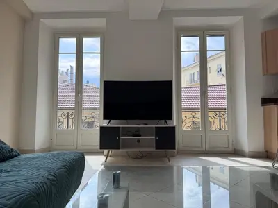 a living room with a flat screen tv on a stand at Beau 4 pièces - hyper centre 8 couchages in Nice