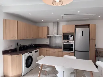 a kitchen with a white table and white appliances at Beau 4 pièces - hyper centre 8 couchages in Nice