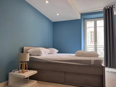 a bedroom with a blue wall and a bed at Beau 4 pièces - hyper centre 8 couchages in Nice