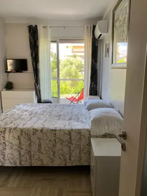 a bedroom with two beds and a window with a view at Chambre de charme in Nice