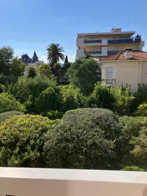a view of a garden with bushes and a building at Chambre de charme in Nice