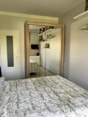 a bedroom with a large bed and a mirror at Chambre de charme in Nice