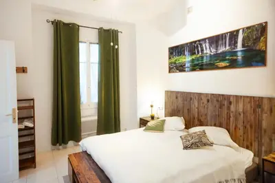 a bedroom with a bed with a wooden headboard and a window at Cap de Nice in Nice