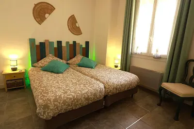 a bedroom with a bed with green pillows at Cap de Nice in Nice