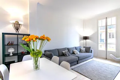 a living room with a couch and a table with flowers at Résidence Estienne d'Orves in Nice