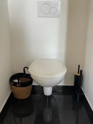 a white toilet in a bathroom with a basket at Duplex Place Garibaldi - Close to port, Old Nice in Nice