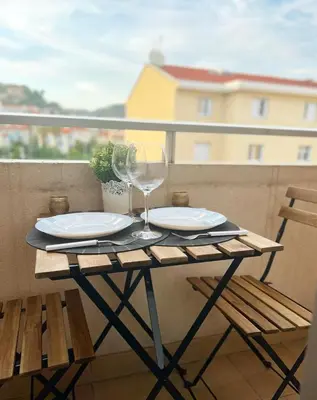 a table with a glass of wine on a balcony at Super studio bord de mer, promenade des anglais in Nice