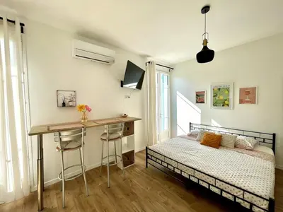a bedroom with a bed and a desk next to a bed at Studio proche mer, avec terrasse et parking in Nice