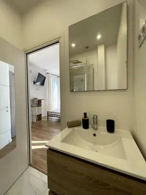 a bathroom with a sink and a mirror at Studio proche mer, avec terrasse et parking in Nice