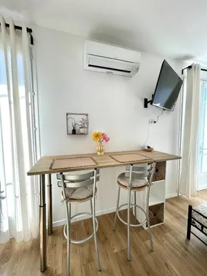 a desk in a room with two bar stools at Studio proche mer, avec terrasse et parking in Nice