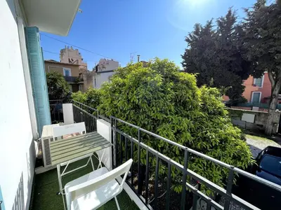 a balcony with a bench and a bush at Studio proche mer, avec terrasse et parking in Nice
