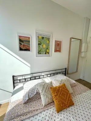 a bedroom with a bed with two pillows and a mirror at Studio proche mer, avec terrasse et parking in Nice