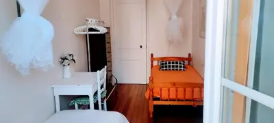 a bedroom with an orange bed and a white table at Guest bedroom in private home, quiet, elegant, 10 mins to beach, 1 triple and 1 double bedrooms in Nice