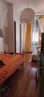 a bedroom with an orange bed and a lamp at Guest bedroom in private home, quiet, elegant, 10 mins to beach, 1 triple and 1 double bedrooms in Nice