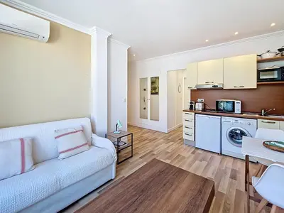 a living room with a white couch and a kitchen at Nestor&Jeeves - CASA SOLANA - Terrace - Central in Nice