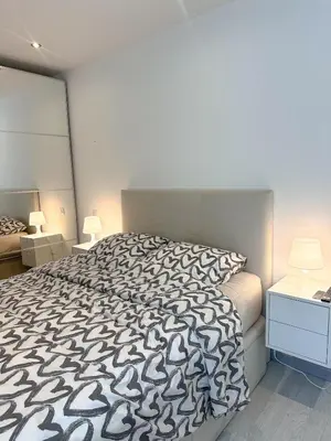 a bedroom with a bed with a black and white comforter at Spacious, quiet apartment in Nice