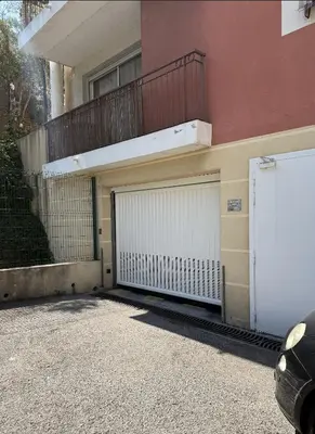 a building with two garage doors and a balcony at Spacious, quiet apartment in Nice
