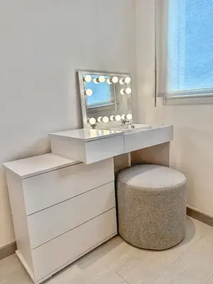 a bathroom with a vanity with a mirror and a stool at Spacious, quiet apartment in Nice