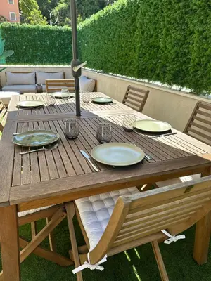 a wooden table with plates on top of it at Spacious, quiet apartment in Nice