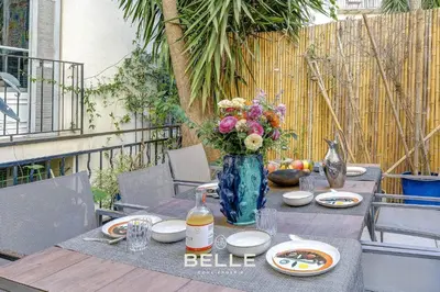 a table with a vase of flowers on top of it at Le Rivoli Niçois - 180m2 - 3 Chambres in Nice