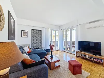 a living room with a blue couch and a tv at Nestor&Jeeves - TROPI AZUR - Terrace - Place du Pin in Nice