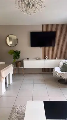 a living room with a couch and a chandelier at Appartement rénové , Climatisé, Terrasse, Parking en sous sol in Saint-Laurent-du-Var