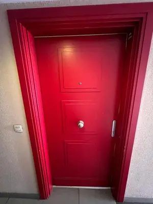 a red door with a silver knob on it at Appartement rénové , Climatisé, Terrasse, Parking en sous sol in Saint-Laurent-du-Var