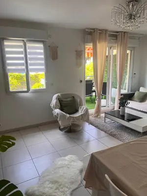 a living room with a couch and a chair at Appartement rénové , Climatisé, Terrasse, Parking en sous sol in Saint-Laurent-du-Var