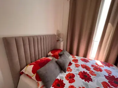 a bed with a floral comforter and two pillows on it at Lovely apartment nice in Nice