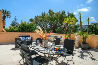 a patio with a glass table and chairs at Nice Fabron, terrasse & piscine dans résidence in Nice