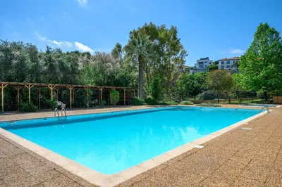 a large blue swimming pool in a yard at Nice Fabron, terrasse & piscine dans résidence in Nice