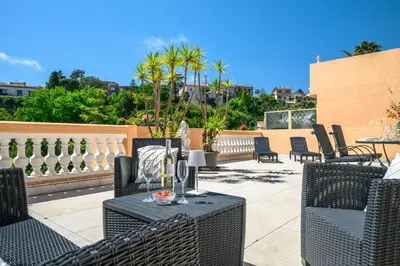 a patio with wicker chairs and tables on a patio at Nice Fabron, terrasse & piscine dans résidence in Nice