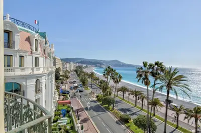 a view of a street with palm trees and the ocean at Charming Riviera Top-Floor Apartment near the Beach in Nice