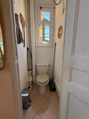 a small bathroom with a toilet and a window at Charming Riviera Top-Floor Apartment near the Beach in Nice