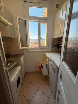 a small kitchen with a washing machine and a window at Charming Riviera Top-Floor Apartment near the Beach in Nice