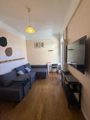 a living room with a blue couch and a table at Charming Riviera Top-Floor Apartment near the Beach in Nice