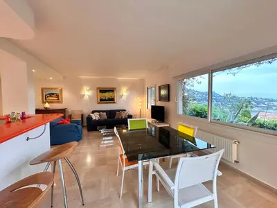 a kitchen and living room with a table and chairs at Golden Mornings, Sea, Garden, Breakfast & Free Parking in Villefranche-sur-Mer
