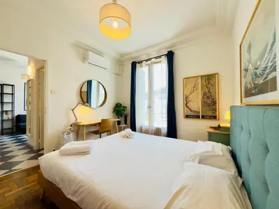 a bedroom with a large white bed and a desk at New Alba 3 Pers WiFi AC in Nice