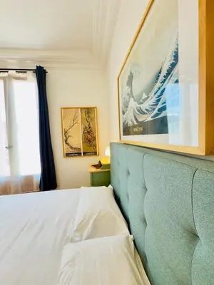a bedroom with a bed with a picture on the wall at New Alba 3 Pers WiFi AC in Nice