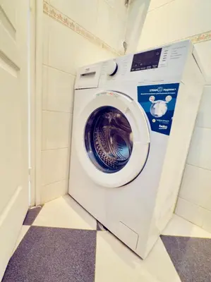 a washing machine in a bathroom with a checkered floor at New Alba 3 Pers WiFi AC in Nice