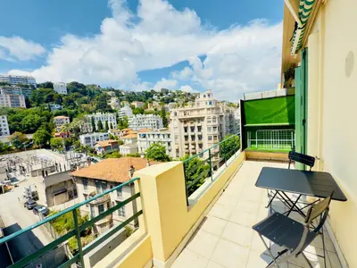 a balcony with a table and a view of a city at New Alba 3 Pers WiFi AC in Nice