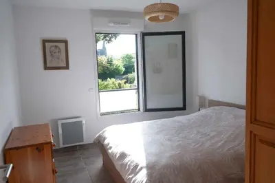 a white bedroom with a bed and a window at Sea view apartment close to beaches in Cagnes-sur-Mer