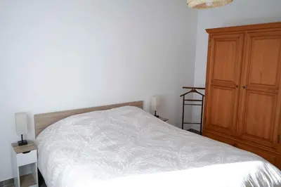 a bedroom with a bed and a wooden cabinet at Sea view apartment close to beaches in Cagnes-sur-Mer