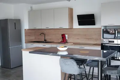 a kitchen with white cabinets and a counter with bar stools at Sea view apartment close to beaches in Cagnes-sur-Mer